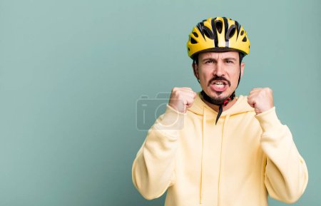 Photo for Adult man shouting aggressively with an angry expression. bike helmet and bicycle concept - Royalty Free Image