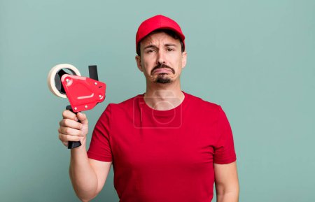Photo for Adult man feeling sad and whiney with an unhappy look and crying. deliveryman packer concept - Royalty Free Image