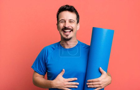 Téléchargez les photos : Un adulte riant à haute voix d'une blague hilarante. concept de fitness et yoga - en image libre de droit