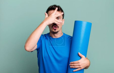 Photo for Adult man looking shocked, scared or terrified, covering face with hand. fitness and yoga concept - Royalty Free Image