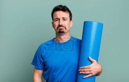 Foto de Hombre adulto sintiéndose triste y quejumbroso con una mirada infeliz y llorando. concepto de fitness y yoga - Imagen libre de derechos