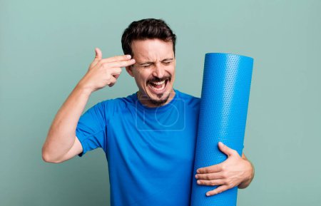 Photo for Adult man looking unhappy and stressed, suicide gesture making gun sign. fitness and yoga concept - Royalty Free Image