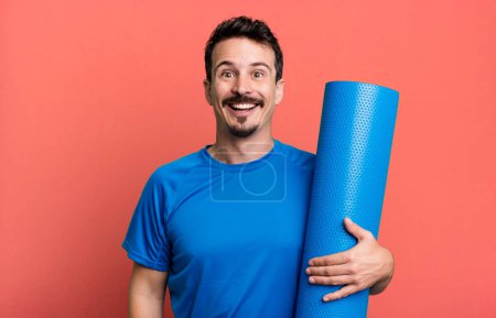 Téléchargez les photos : Homme adulte regardant heureux et agréablement surpris. concept de fitness et yoga - en image libre de droit