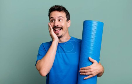 Téléchargez les photos : Homme adulte se sentant heureux, excité et surpris. concept de fitness et yoga - en image libre de droit
