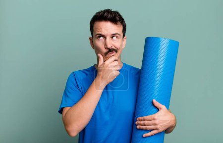 Foto de Hombre adulto pensando, sintiéndose dudoso y confundido. concepto de fitness y yoga - Imagen libre de derechos