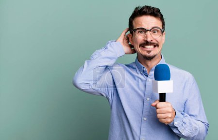 Foto de Adult man feeling stressed, anxious or scared, with hands on head with a microphone. presenter or journalist concept - Imagen libre de derechos