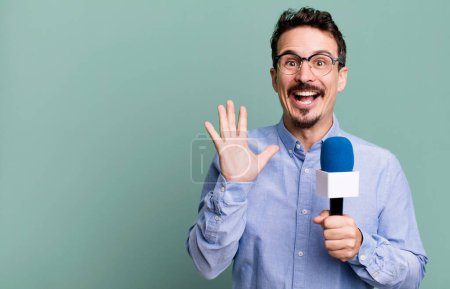 Foto de Adult man feeling happy and astonished at something unbelievable with a microphone. presenter or journalist concept - Imagen libre de derechos