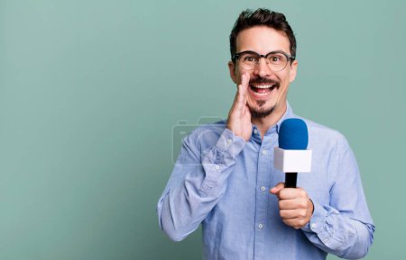 Foto de Adult man feeling happy,giving a big shout out with hands next to mouth with a microphone. presenter or journalist concept - Imagen libre de derechos