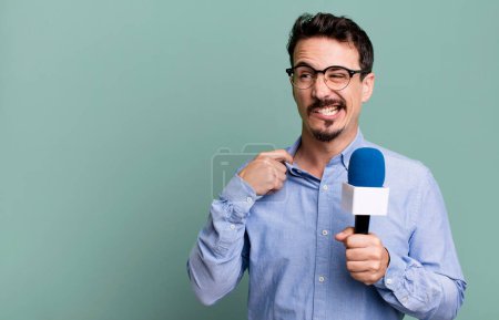 Téléchargez les photos : Adult man feeling stressed, anxious, tired and frustrated with a microphone. presenter or journalist concept - en image libre de droit