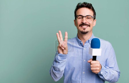 Photo for Adult man smiling and looking friendly, showing number three with a microphone. presenter or journalist concept - Royalty Free Image