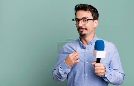 Téléchargez les photos : Adult man looking arrogant, successful, positive and proud with a microphone. presenter or journalist concept - en image libre de droit