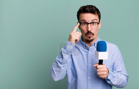 Photo for Adult man looking surprised, realizing a new thought, idea or concept with a microphone. presenter or journalist concept - Royalty Free Image