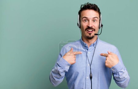 Photo for Adult man feeling happy and pointing to self with an excited with headset. telemarketer operator concept - Royalty Free Image