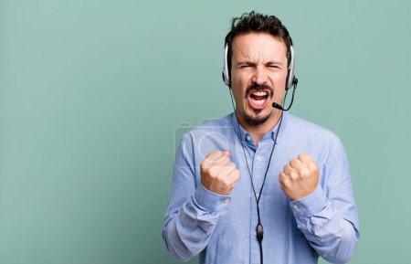 Photo for Adult man shouting aggressively with an angry expression with headset. telemarketer operator concept - Royalty Free Image