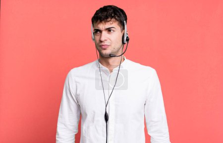 Foto de Hombre adulto sintiéndose triste, molesto o enojado y mirando hacia un lado con auriculares. concepto de operador de telemarketer - Imagen libre de derechos