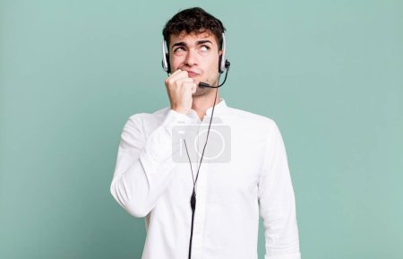 Foto de Hombre adulto pensando, sintiéndose dudoso y confundido con auriculares. concepto de operador de telemarketer - Imagen libre de derechos