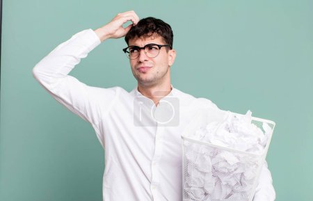 Foto de Hombre adulto sintiéndose desconcertado y confundido, rascándose la cabeza. bolas de papel errores basura - Imagen libre de derechos