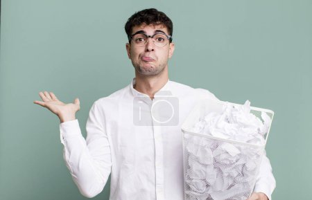 Téléchargez les photos : Homme adulte se sentant perplexe et confus et doutant. boules de papier erreurs poubelle - en image libre de droit