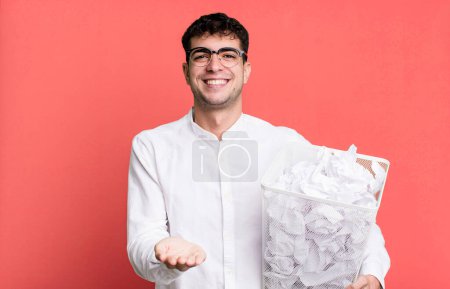 Téléchargez les photos : Homme adulte souriant heureux avec amical et offrant et montrant un concept. boules de papier erreurs poubelle - en image libre de droit