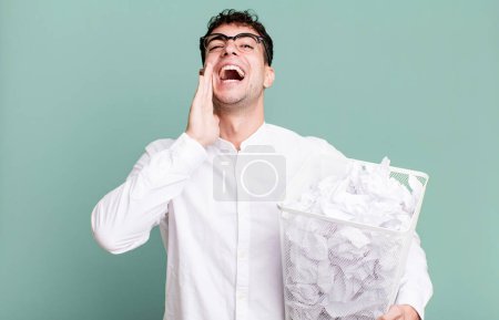 Photo for Adult man feeling happy,giving a big shout out with hands next to mouth. paper balls mistakes trash - Royalty Free Image