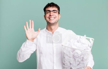 Foto de Hombre adulto sonriendo felizmente, saludándote con la mano, dándote la bienvenida y saludándote. bolas de papel errores basura - Imagen libre de derechos