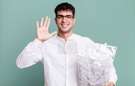 Photo for Adult man smiling and looking friendly, showing number five. paper balls mistakes trash - Royalty Free Image