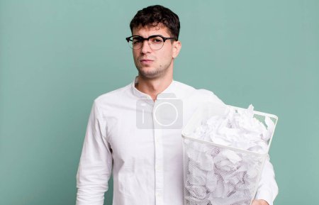Photo for Adult man feeling sad, upset or angry and looking to the side. paper balls mistakes trash - Royalty Free Image