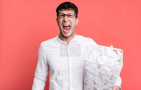Téléchargez les photos : Homme adulte criant agressivement, l'air très en colère. boules de papier erreurs poubelle - en image libre de droit