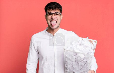 Photo for Adult man feeling disgusted and irritated and tongue out. paper balls mistakes trash - Royalty Free Image