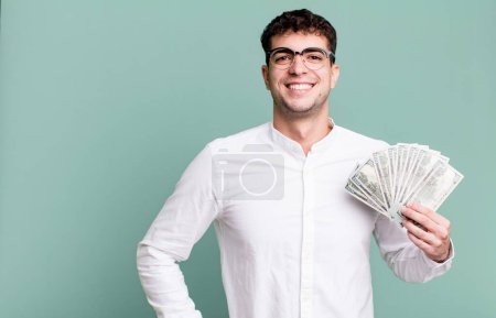 Photo for Adult man smiling happily with a hand on hip and confident. dollar banknotes concept - Royalty Free Image