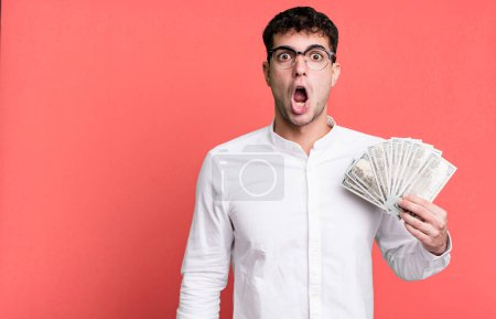 Foto de Hombre adulto que parece muy sorprendido o sorprendido. concepto de billetes en dólares - Imagen libre de derechos