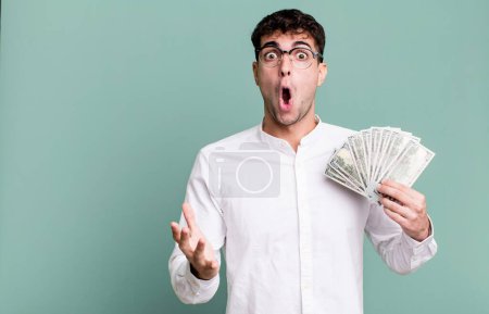 Foto de Hombre adulto sorprendido, sorprendido y asombrado con una sorpresa increíble. concepto de billetes en dólares - Imagen libre de derechos
