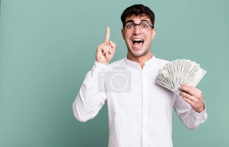 Foto de Hombre adulto sentirse como un genio feliz y emocionado después de darse cuenta de una idea. concepto de billetes en dólares - Imagen libre de derechos