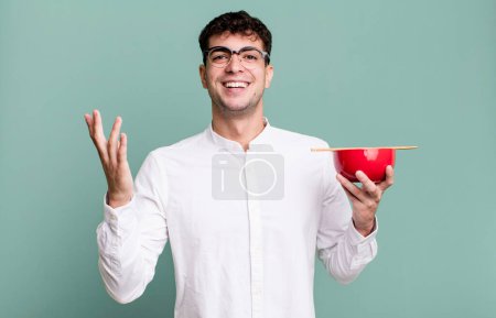Téléchargez les photos : Homme adulte se sentant heureux, surpris de réaliser une solution ou une idée tenant un bol de nouilles ramen - en image libre de droit