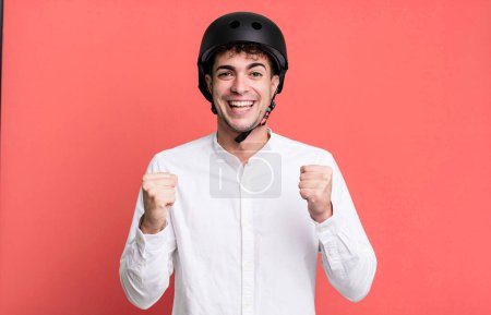 Téléchargez les photos : Homme adulte se sentant choqué, rire et célébrer le succès. concept de motard de ville - en image libre de droit