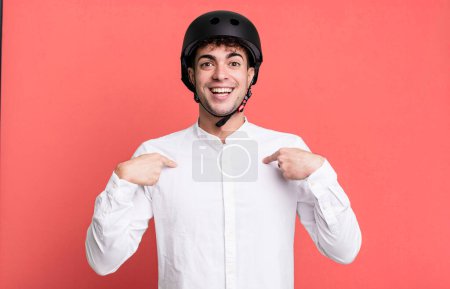 Téléchargez les photos : Homme adulte se sentant heureux et pointant vers soi-même avec un excité. concept de motard de ville - en image libre de droit
