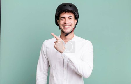 Photo for Adult man looking excited and surprised pointing to the side. city motorbike rider concept - Royalty Free Image