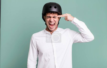 Foto de Hombre adulto que parece infeliz y estresado, gesto suicida haciendo señal de arma. ciudad concepto de motociclista - Imagen libre de derechos