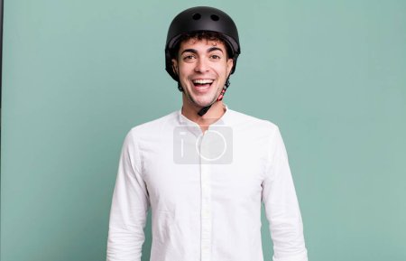 Téléchargez les photos : Homme adulte regardant heureux et agréablement surpris. concept de motard de ville - en image libre de droit