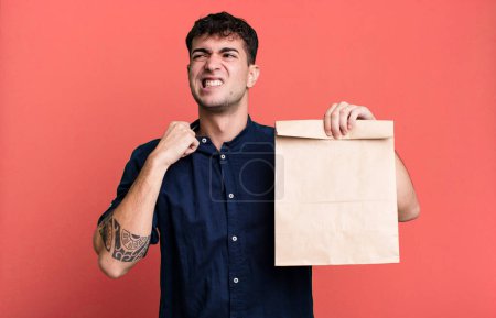 Photo for Adult man feeling stressed, anxious, tired and frustrated with a take away breakfast paper bag with a take away breakfast paper bag - Royalty Free Image