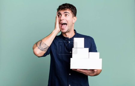 Téléchargez les photos : Homme adulte se sentant heureux, excité et surpris avec des emballages de produits vierges - en image libre de droit