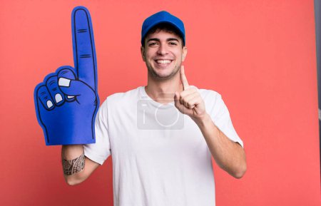 Photo for Adult man smiling proudly and confidently making number one. number one fan concept - Royalty Free Image