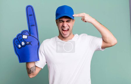 Foto de Hombre adulto que parece infeliz y estresado, gesto suicida haciendo señal de arma. concepto de ventilador número uno - Imagen libre de derechos