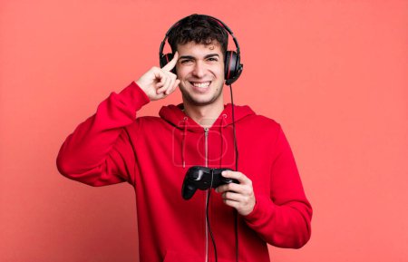 Foto de Hombre adulto sintiéndose confundido y perplejo, mostrando que está loco con auriculares y un controlador. concepto de jugador - Imagen libre de derechos