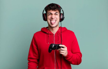 Foto de Hombre adulto sentirse disgustado e irritado y la lengua con auriculares y un controlador. concepto de jugador - Imagen libre de derechos