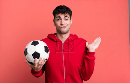 Foto de Hombre adulto sintiéndose desconcertado y confundido y dudando. concepto de fútbol y deporte - Imagen libre de derechos