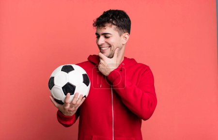 Photo for Adult man smiling with a happy, confident expression with hand on chin. soccer and sport concept - Royalty Free Image