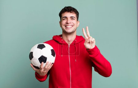 Foto de Hombre adulto sonriendo y mirando feliz, haciendo gestos de victoria o paz. concepto de fútbol y deporte - Imagen libre de derechos