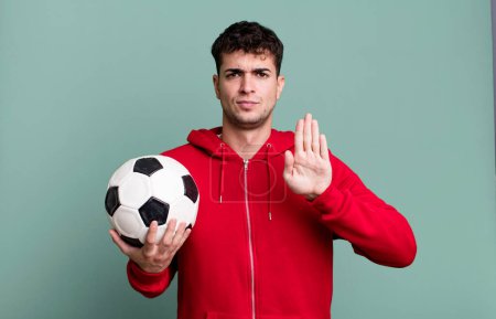 Photo for Adult man looking serious showing open palm making stop gesture. soccer and sport concept - Royalty Free Image