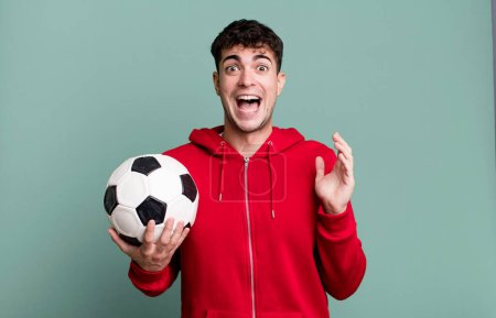 Téléchargez les photos : Homme adulte se sentant heureux et étonné de quelque chose d'incroyable. concept de football et de sport - en image libre de droit